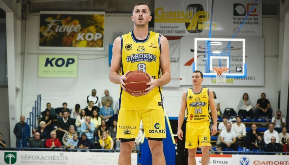 Homme musclé s'entraînant dans une salle de sport moderne, tenant des disques de fonte