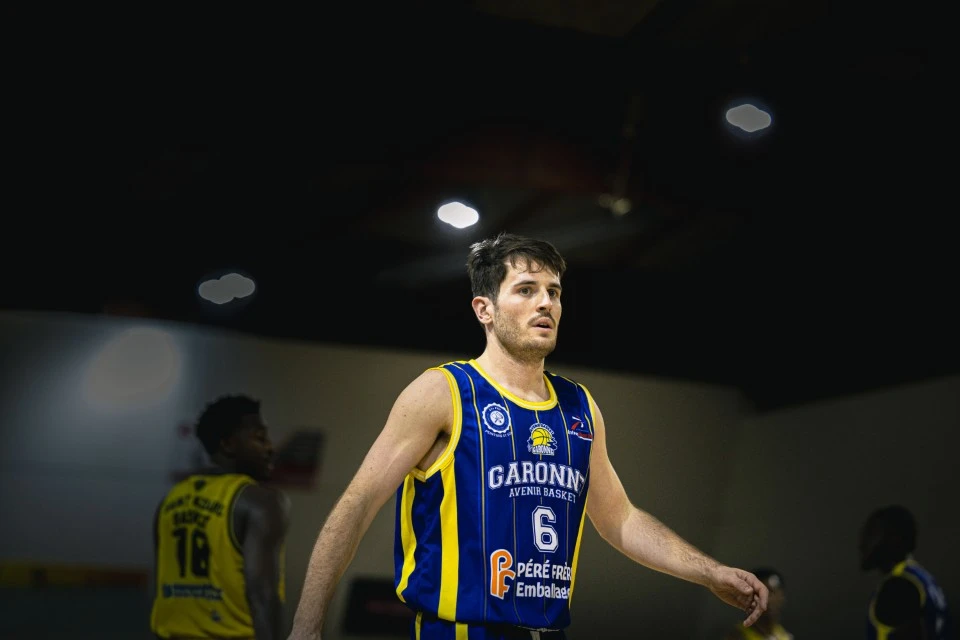 Homme musclé s'entraînant dans une salle de sport moderne, tenant des disques de fonte